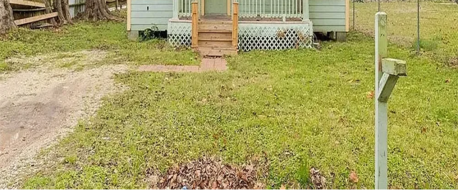 Cropped front yard view showing the mailbox and carport approach at 7101 Wendemere St